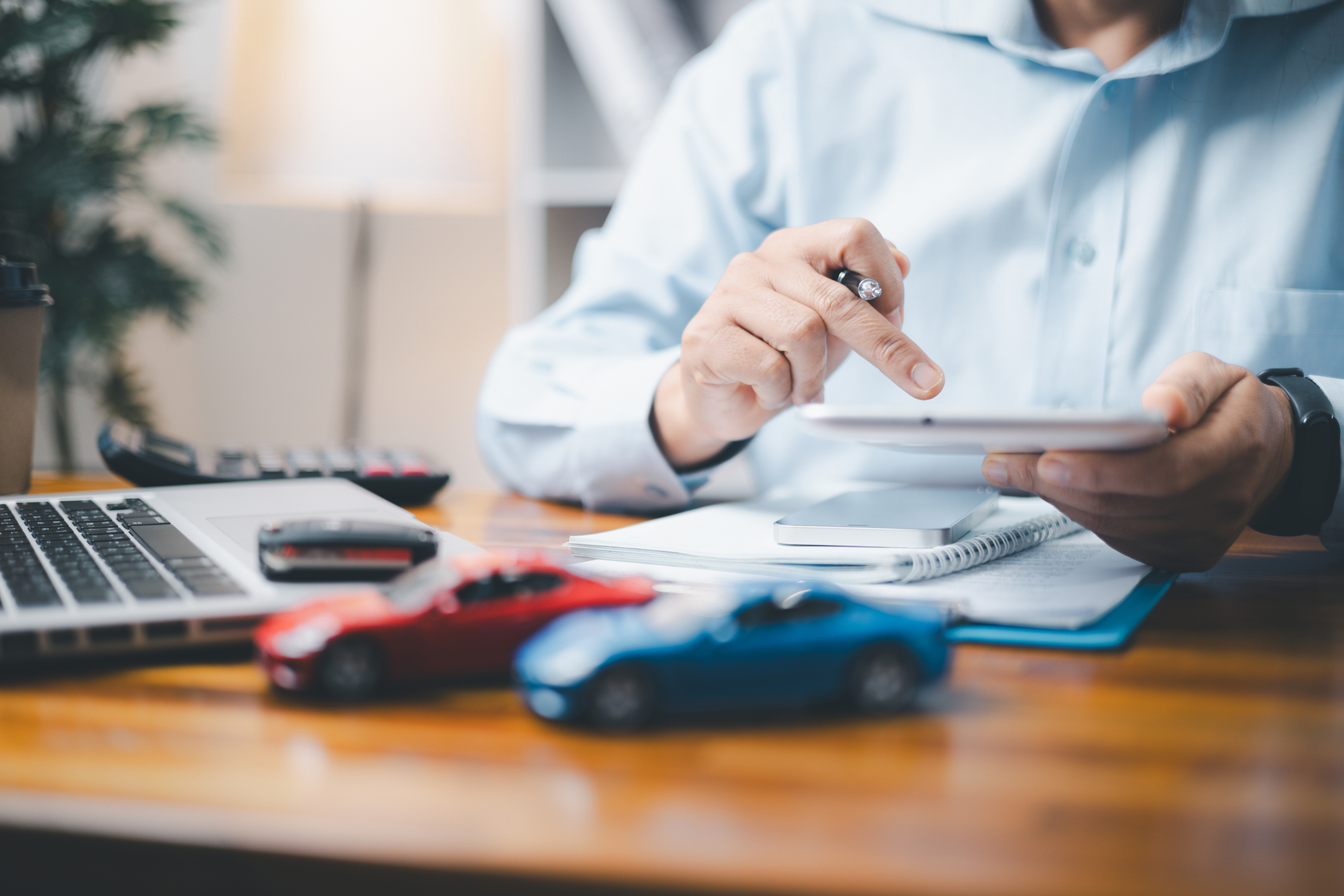 Un homme comparant des assurances auto avec une calculatrice